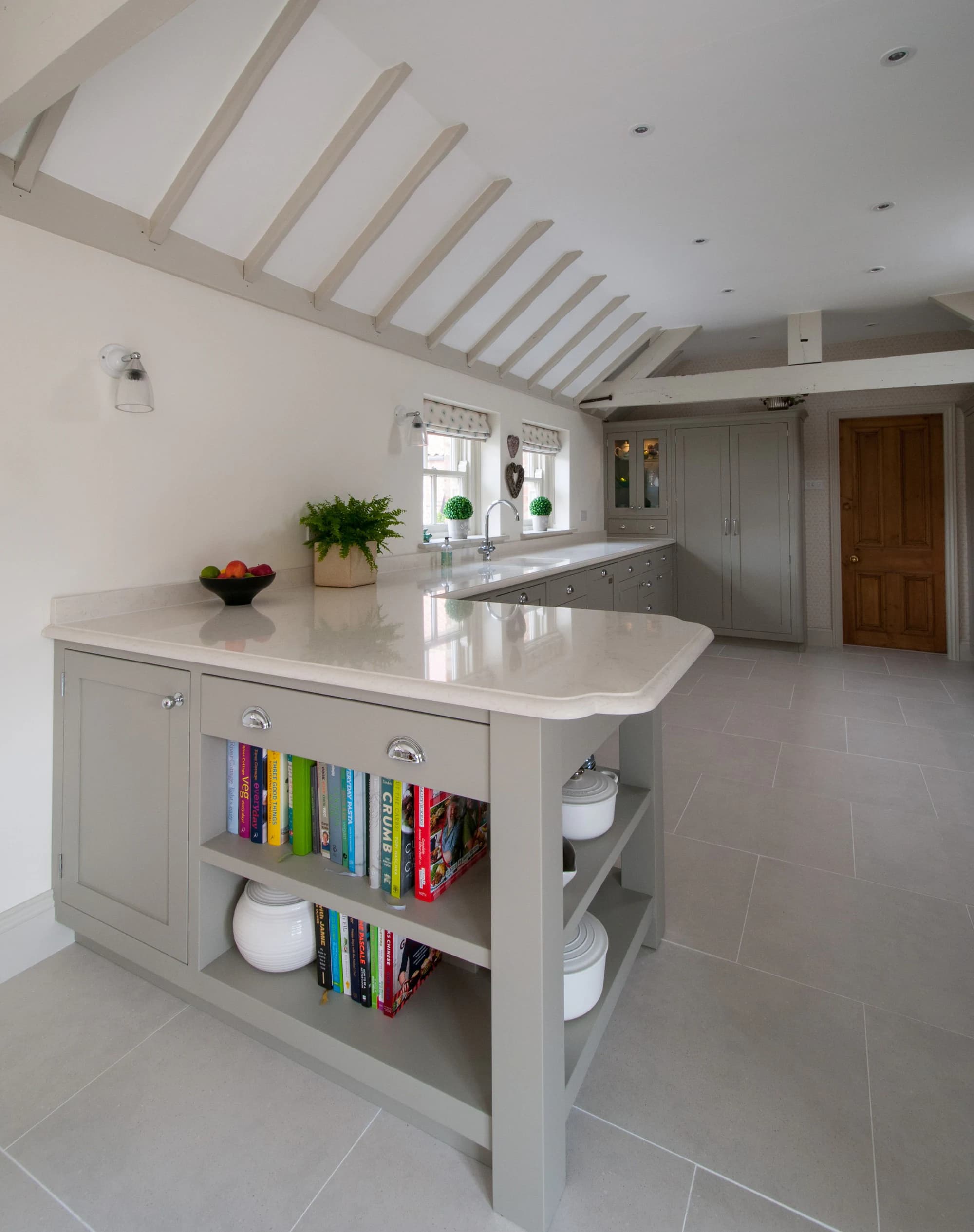 Kitchen island with open book shelving and a curved worktop end