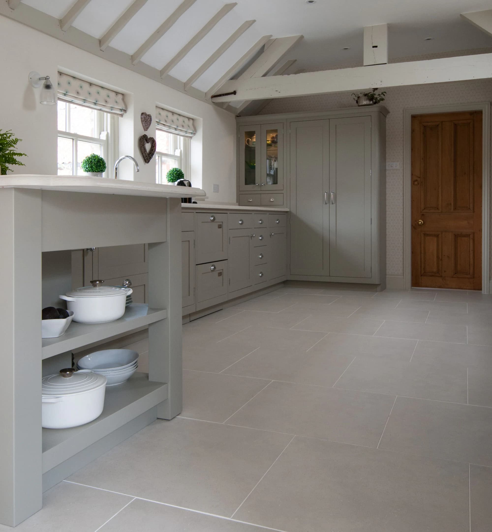 Open shelving at the end of the island with cookware