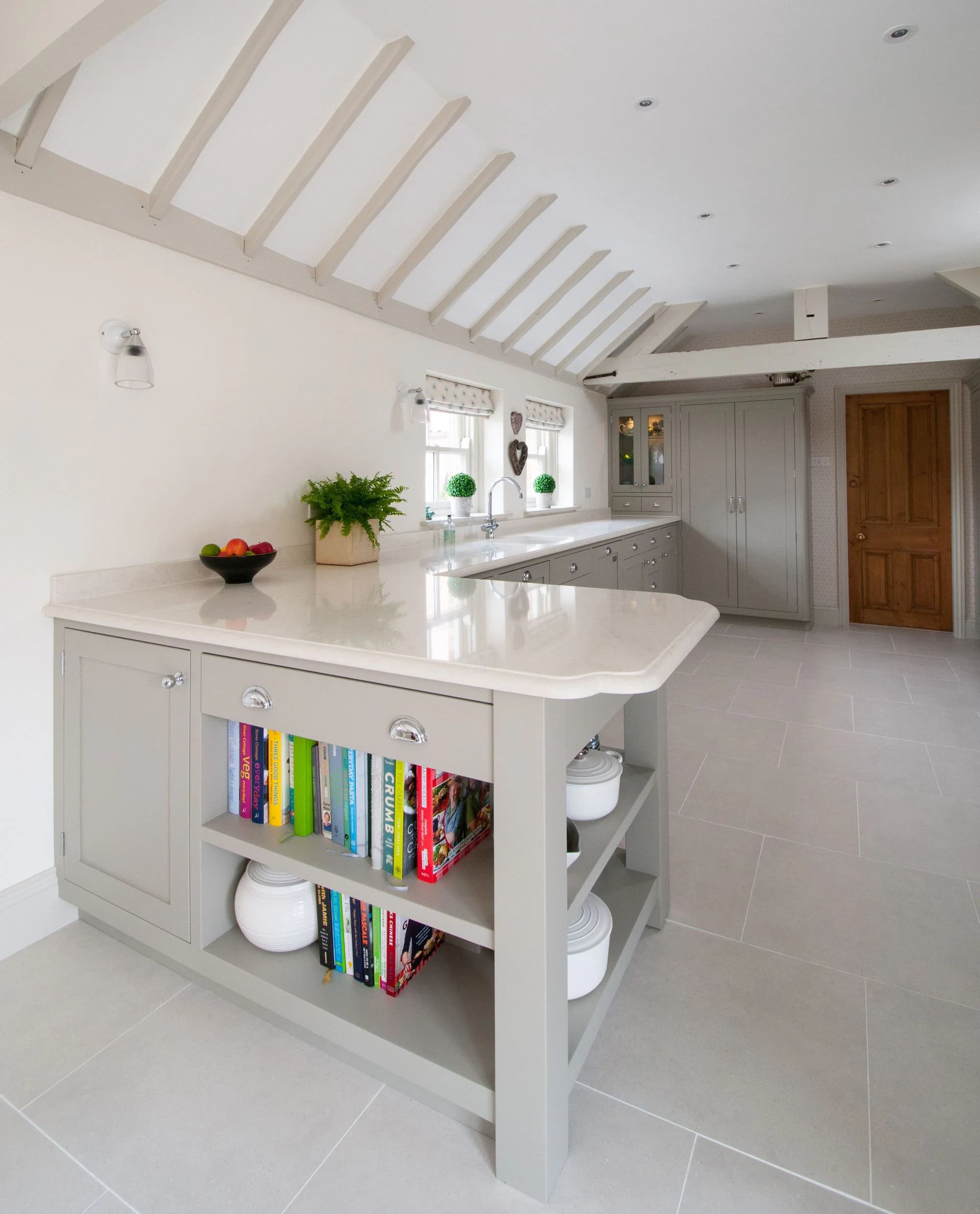 Painted kitchen island viewed across the light-filled room
