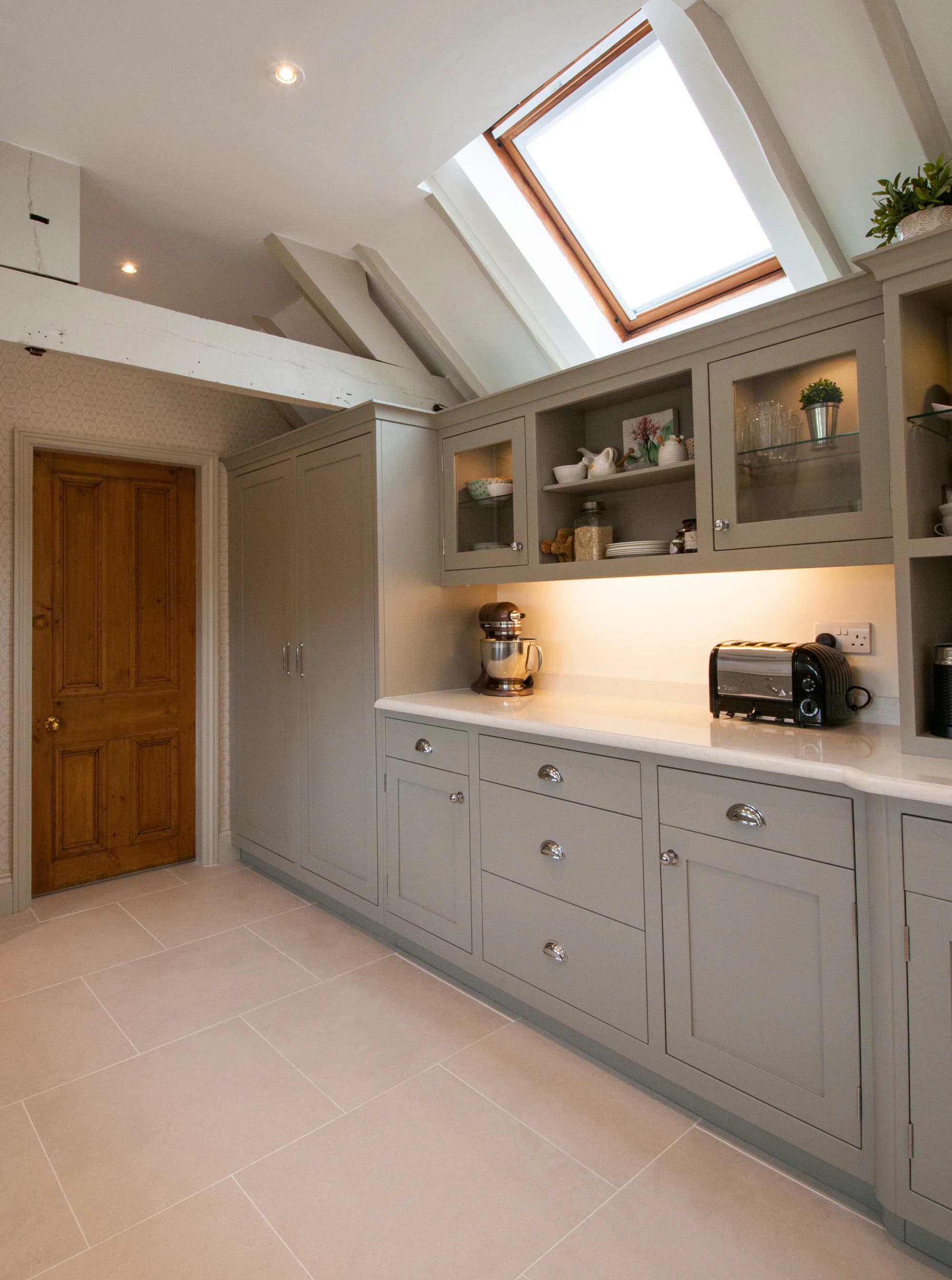 Full run of painted cabinets beneath the exposed roof structure