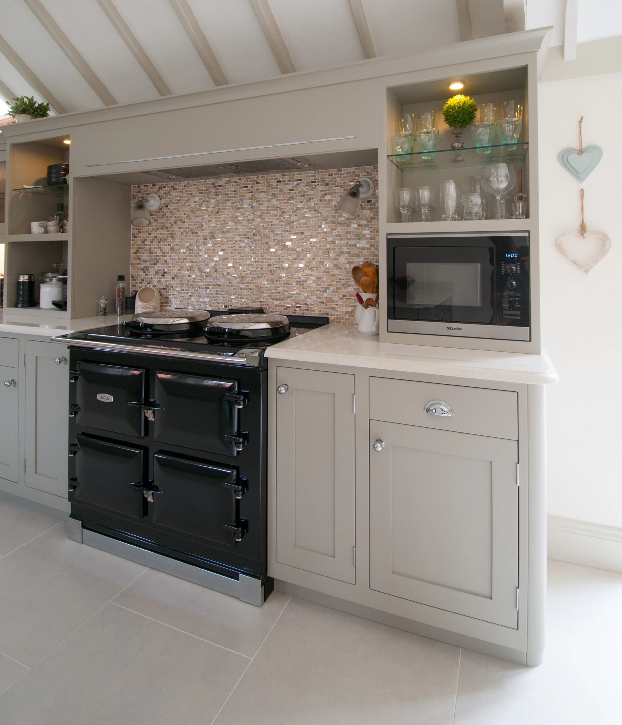 Aga cooking area with open shelving and integrated appliances