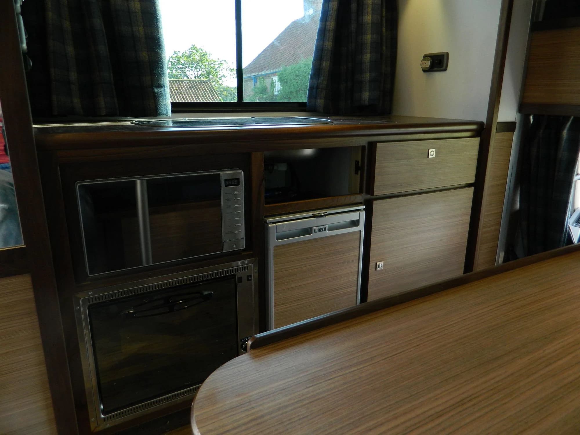 Close view of the timber horsebox kitchen with sink, hob and integrated appliances