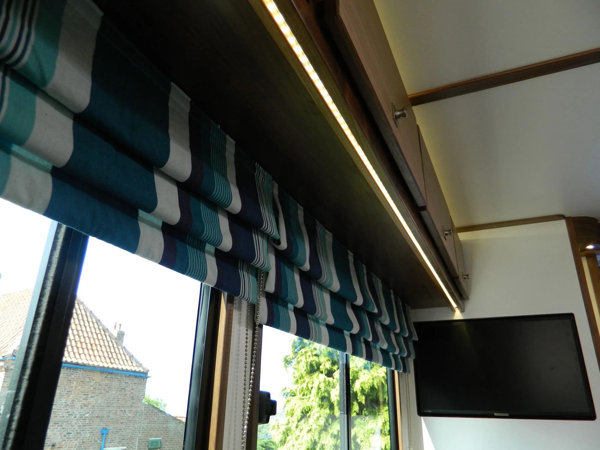 Fitted horsebox window framed by timber cabinetry and warm concealed lighting