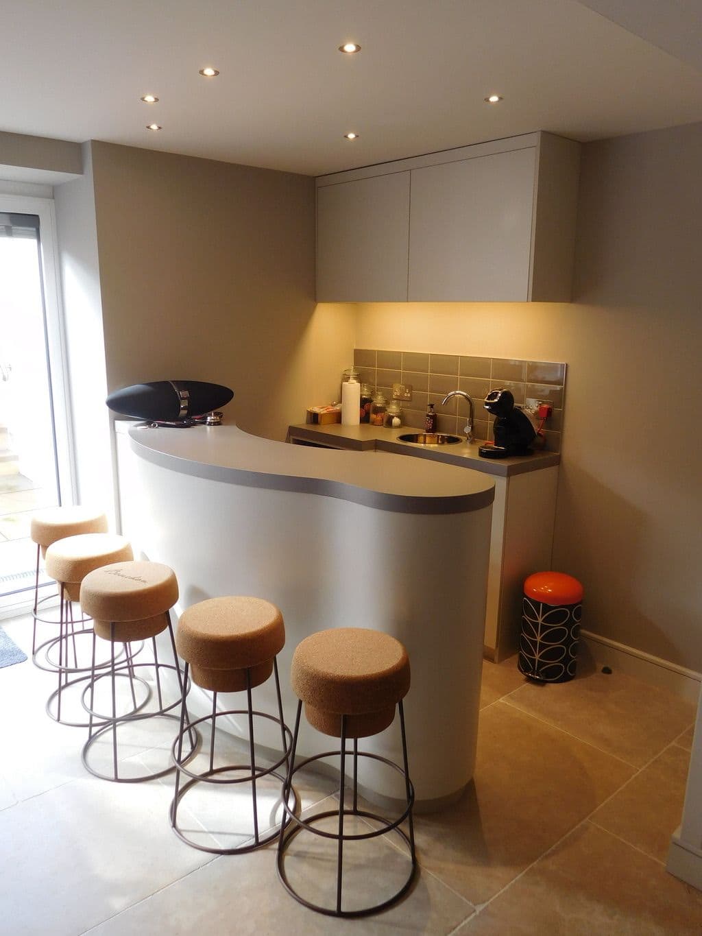 Wide view of the curved home cinema bar with stools and illuminated shelves