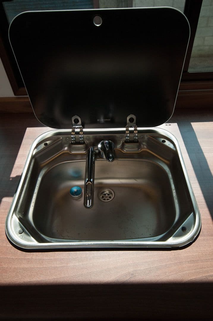 Compact inset sink and rounded timber worktop in the horsebox kitchen