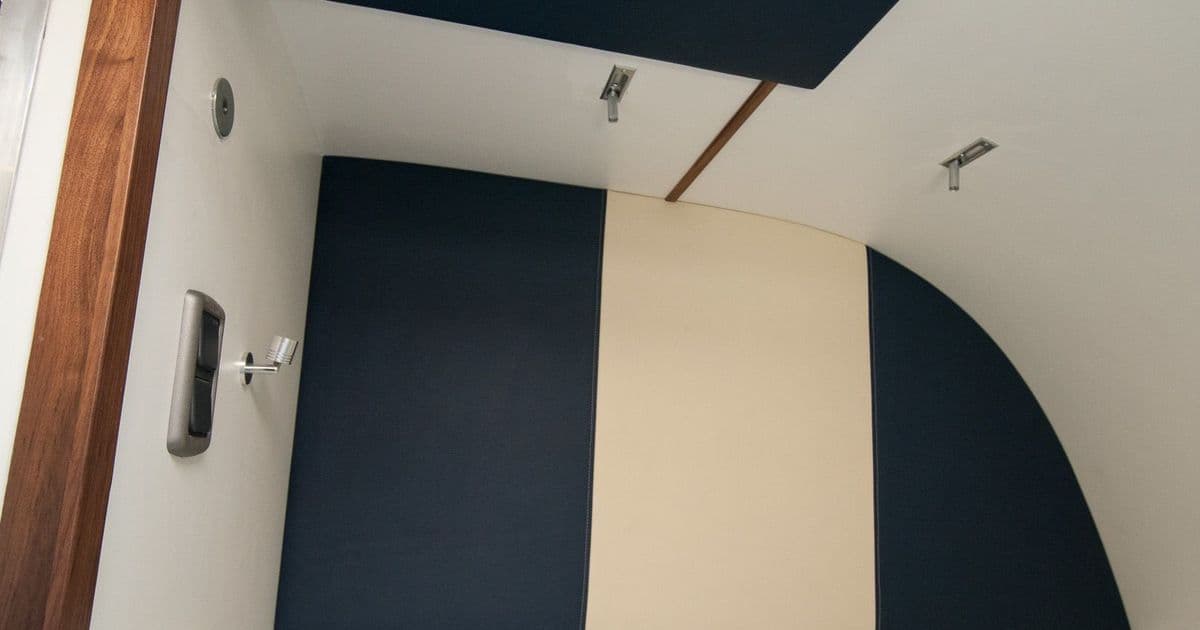 Upholstered sleeping area with fitted graphic wall panel inside the horsebox